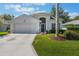 Charming single-story home with a two-car garage, lovely landscaping, and a well-manicured lawn at 5560 Squires Dr, Leesburg, FL 34748