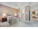 Comfortable bedroom with a ceiling fan, carpet floors, a view of the bath, and a glimpse into the living area at 5560 Squires Dr, Leesburg, FL 34748