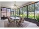 Enclosed porch featuring large windows with outside views, a ceiling fan, and comfortable furnishings at 5560 Squires Dr, Leesburg, FL 34748