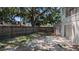 Backyard featuring a wooden fence, mature trees, and a concrete patio area at 609 Whittingham Pl, Lake Mary, FL 32746