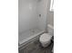 Bathroom showcasing a tiled shower and updated fixtures with modern gray flooring at 609 Whittingham Pl, Lake Mary, FL 32746