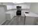 Modern kitchen featuring white cabinetry, quartz countertops, and stainless steel appliances at 609 Whittingham Pl, Lake Mary, FL 32746