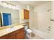 Bathroom with tile flooring, wooden cabinets, bathtub with shower and neutral decor at 6169 Metrowest Blvd # 308, Orlando, FL 32835