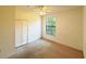 A carpeted bedroom features a ceiling fan, window, and closet at 6169 Metrowest Blvd # 308, Orlando, FL 32835