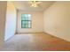 Carpeted bedroom with a ceiling fan and a large window at 6169 Metrowest Blvd # 308, Orlando, FL 32835