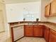 Well-lit kitchen showing oak cabinets, laminate countertops, and tile floors at 6169 Metrowest Blvd # 308, Orlando, FL 32835