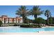 Beautiful community pool with palm trees and lounge chairs at 6169 Metrowest Blvd # 308, Orlando, FL 32835