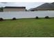 Large backyard featuring a privacy fence, green grass, and manicured landscaping at 6800 Se 12Th Pl, Ocala, FL 34472