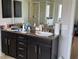 Bathroom with double vanity sinks, dark wood cabinets, and a large mirror at 6800 Se 12Th Pl, Ocala, FL 34472