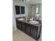 Bathroom vanity featuring double sinks, dark cabinets, granite countertops, and a large mirror at 6800 Se 12Th Pl, Ocala, FL 34472