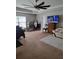 Primary bedroom with a ceiling fan, carpeted floors, comfortable bed and seating, and bright window at 6800 Se 12Th Pl, Ocala, FL 34472