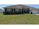 Attractive one-story home boasting a well-maintained lawn, complemented by dark shutters and a clean garage door at 6800 Se 12Th Pl, Ocala, FL 34472
