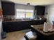 Spacious kitchen with dark cabinetry, a large window offering natural light, and ample counter space at 6800 Se 12Th Pl, Ocala, FL 34472