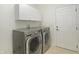 Laundry room with white cabinets and a gray front-load washer and dryer at 6941 Piazza St, Orlando, FL 32819