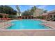Community pool with a paved deck surrounded by chairs and lounge seating at 6941 Piazza St, Orlando, FL 32819