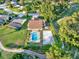 An aerial perspective showing a pool, a volleyball court, and large green trees at 6969 Edgeworth Dr, Orlando, FL 32819