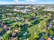 Panoramic aerial view of a neighborhood surrounded by green golf courses and tree-lined streets under a blue sky at 6969 Edgeworth Dr, Orlando, FL 32819
