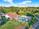 Beautiful aerial view showcasing a home with a pool, sand pit, and lush greenery against a scenic backdrop at 6969 Edgeworth Dr, Orlando, FL 32819