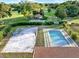 Aerial view showcases the pool and volleyball court next to a green golf course at 6969 Edgeworth Dr, Orlando, FL 32819