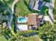 An aerial view of property featuring a pool, volleyball court, and lush landscaping, offering a private oasis at 6969 Edgeworth Dr, Orlando, FL 32819