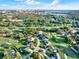 Scenic aerial view of a community featuring tree-lined streets, green spaces, and a lake in the distance at 6969 Edgeworth Dr, Orlando, FL 32819