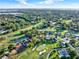 Stunning aerial view of a golf course community with lush green fairways and beautiful homes in a scenic landscape at 6969 Edgeworth Dr, Orlando, FL 32819