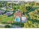 Aerial view of a home, pool, volleyball court and landscaping near the golf course at 6969 Edgeworth Dr, Orlando, FL 32819