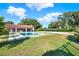 Spacious backyard featuring a pool, volleyball court, lush lawn, and covered patio area at 6969 Edgeworth Dr, Orlando, FL 32819