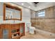 Bathroom featuring glass shower, toilet and wood vanity with unique glass vessel sink at 6969 Edgeworth Dr, Orlando, FL 32819