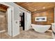 Modern bathroom featuring a freestanding tub, sleek fixtures, and a wood accent wall at 6969 Edgeworth Dr, Orlando, FL 32819