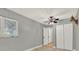 Cozy bedroom features a ceiling fan, neutral gray paint, closet, and wood-look floors at 6969 Edgeworth Dr, Orlando, FL 32819