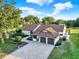 Charming home featuring a tile roof, attached garage and a paver driveway surrounded by manicured landscaping at 6969 Edgeworth Dr, Orlando, FL 32819