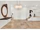 Elegant foyer featuring tile floors, grand mirror, stylish chandelier, and staircase at 6969 Edgeworth Dr, Orlando, FL 32819