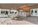 Covered lanai including an outdoor bar area with seating, dining table, and decorative hanging chair at 6969 Edgeworth Dr, Orlando, FL 32819