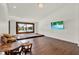 Well-lit living room with hardwood flooring, a flat-screen TV, and a view to the yard at 6969 Edgeworth Dr, Orlando, FL 32819
