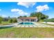 Backyard pool and volleyball court with a covered patio and well-manicured green lawn at 6969 Edgeworth Dr, Orlando, FL 32819