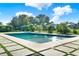 A sparkling pool with concrete tile surround is the centerpiece of this private backyard at 6969 Edgeworth Dr, Orlando, FL 32819