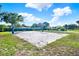 Outdoor sand volleyball court with blue net surrounded by well-maintained green grass at 6969 Edgeworth Dr, Orlando, FL 32819