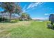 Expansive backyard showcasing well-maintained lawn, lake view, and screened-in outdoor living at 7263 Oakmoss Loop, Davenport, FL 33837