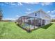 Landscaped backyard with screened pool, spa, and patio offers scenic views and privacy at 7263 Oakmoss Loop, Davenport, FL 33837