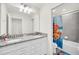 Bathroom with double sinks, granite countertops, and a shower with Paw Patrol themed curtain at 7263 Oakmoss Loop, Davenport, FL 33837
