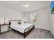Bright bedroom featuring a queen bed, gray carpet, and a window offering natural light at 7263 Oakmoss Loop, Davenport, FL 33837