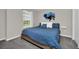 Bedroom with blue queen bed, white floating shelves, carpeted floors, and a window at 7263 Oakmoss Loop, Davenport, FL 33837