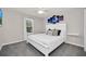 Bedroom with white queen bed, white floating shelves, carpeted floors, and a window at 7263 Oakmoss Loop, Davenport, FL 33837
