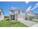 Inviting two-story home with a light blue exterior, white accents and well-kept lawn at 7263 Oakmoss Loop, Davenport, FL 33837