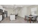 Open-concept kitchen features a center island, stainless steel appliances, and modern pendant lighting at 7263 Oakmoss Loop, Davenport, FL 33837