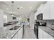 Spacious kitchen featuring a breakfast bar, granite countertops, and stainless steel appliances at 7263 Oakmoss Loop, Davenport, FL 33837