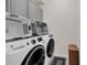 Functional laundry room with washer, dryer, storage cabinets, and utility sink offering convenience at 7263 Oakmoss Loop, Davenport, FL 33837