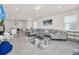 Open living space with a view of kitchen and island with a large comfortable gray sectional at 7263 Oakmoss Loop, Davenport, FL 33837