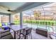 Outdoor patio featuring a table, chairs, and a screened pool, designed for dining and entertaining at 7263 Oakmoss Loop, Davenport, FL 33837